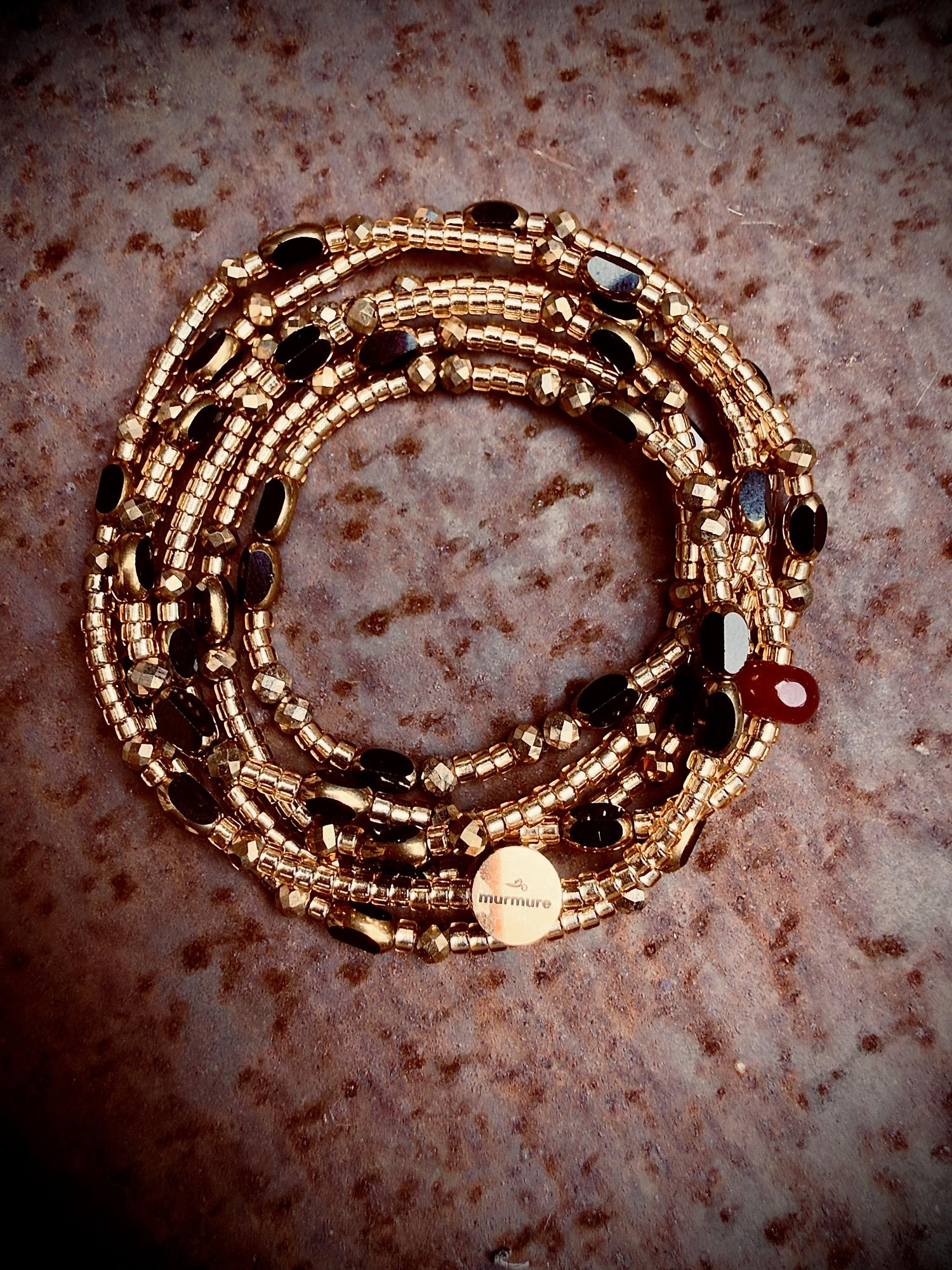 Bracelet Murmure enroulé, perles dorées et noires, pierre rouge
